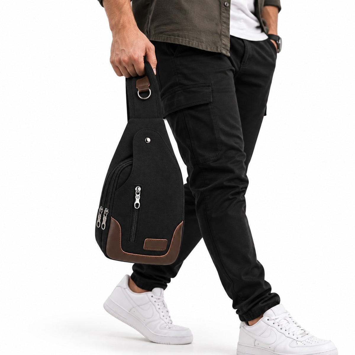Sac bandoulière Univers Sac noir en toile avec détails marron, porté à la main par un homme en tenue décontractée.
