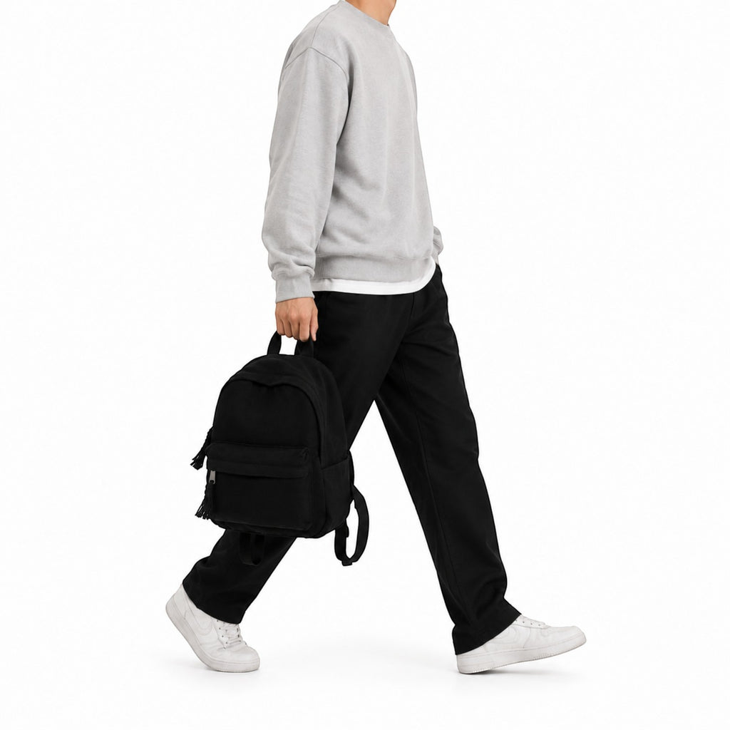 Homme portant un petit sac à dos noir en toile Univers Sac, style décontracté pour les voyages ou le quotidien.