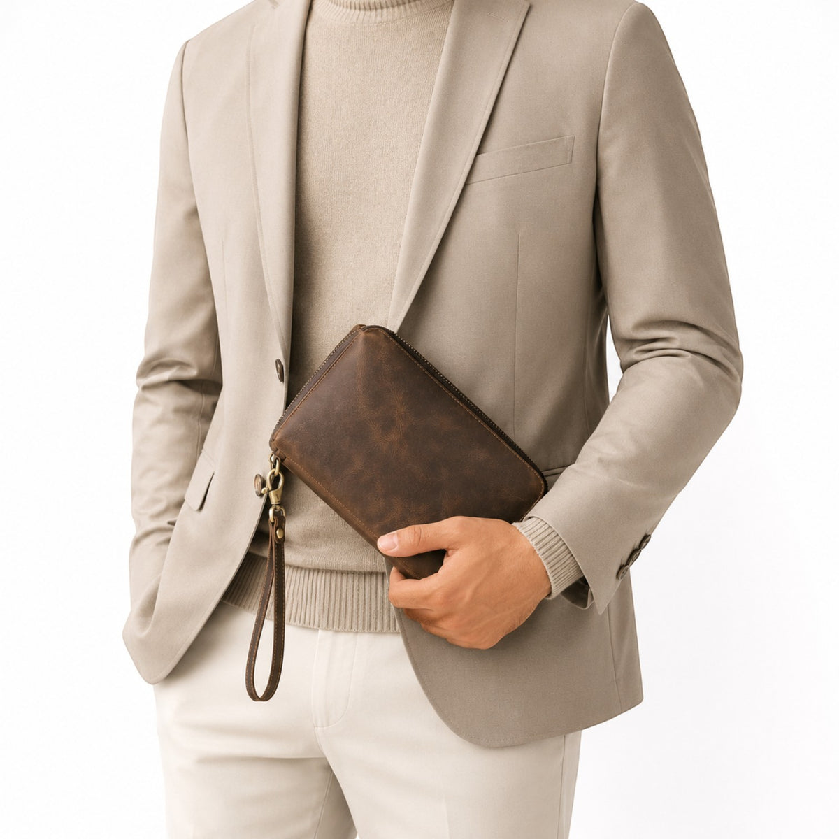 Pochette Univers Sac en cuir véritable marron style vintage avec dragonne portée par un homme en blazer beige