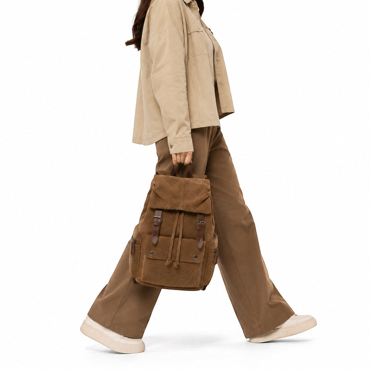 Sac à dos vintage marron en toile et cuir par Univers Sac, porté à la main par une femme en tenue décontractée.