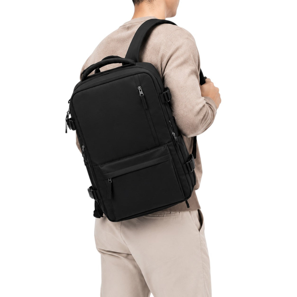Sac à dos de voyage noir Univers Sac en nylon, format cabine, porté par un homme sur fond blanc.