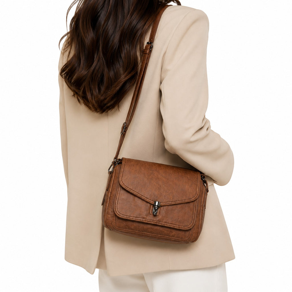 Sac bandoulière vintage en cuir marron de la marque Univers Sac, avec fermeture à fermoir et poche intérieure.