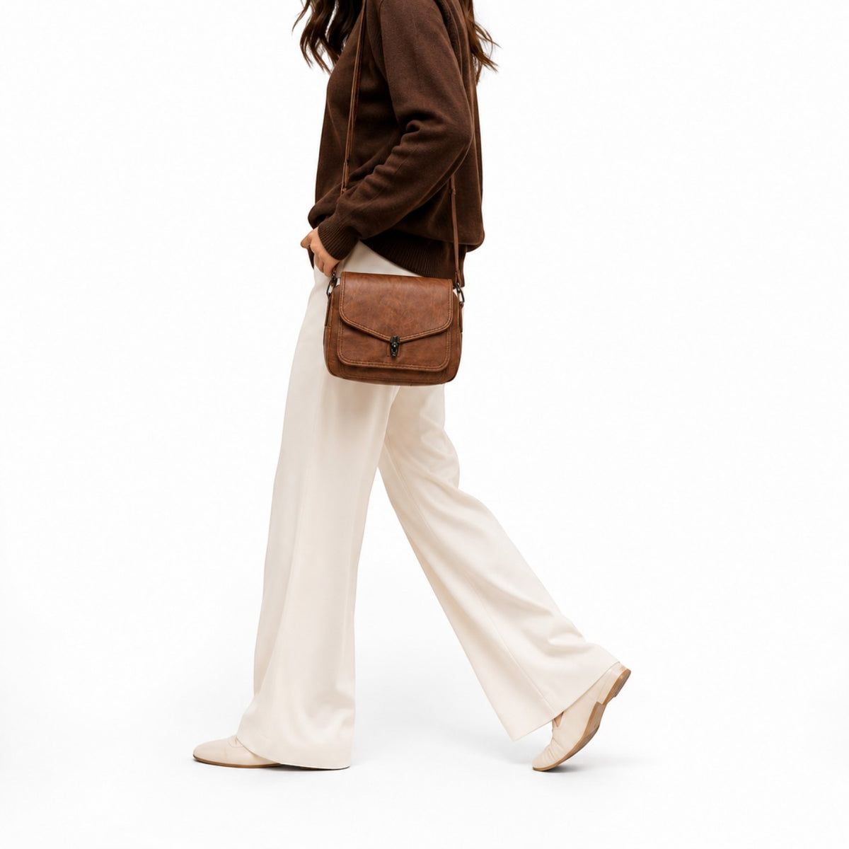 Sac bandoulière vintage en cuir PU marron avec fermeture à rabat et bijouterie argentée, porté par une femme.