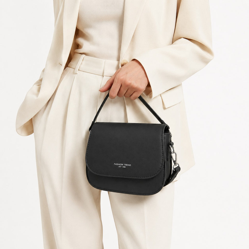 Sac à bandoulière noir en cuir PU souple de Univers Sac, avec une fermeture à rabat et une petite anse.