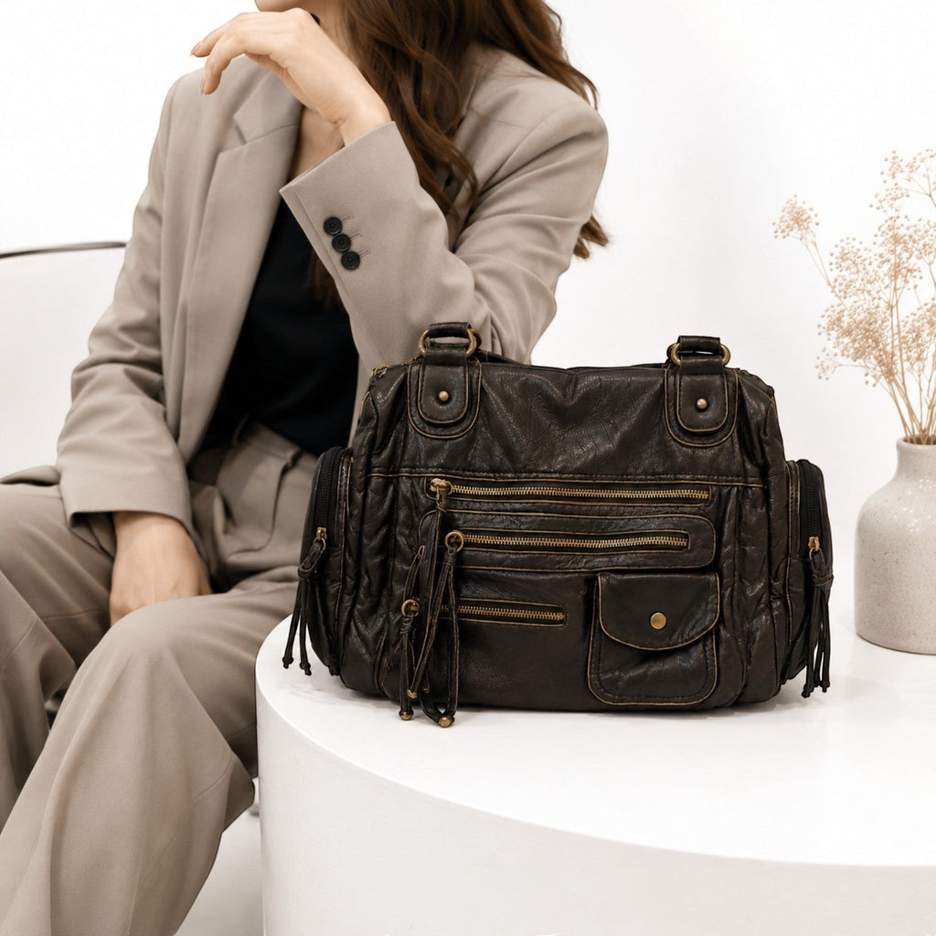 Sac bandoulière noir en cuir PU souple, multi-poches zippées, avec franges, par Univers Sac.