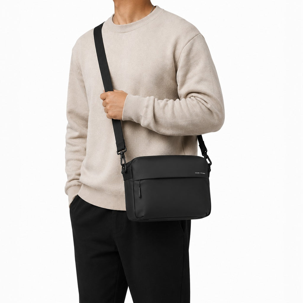 Sac bandoulière noir imperméable Mark Ryden porté par un homme, style décontracté et fonctionnel