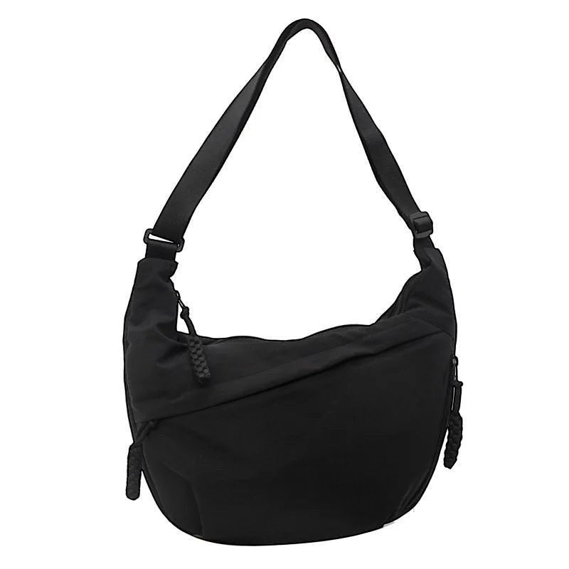 Sac à bandoulière noir en nylon de Univers Sac, forme hobo, avec fermeture éclair et poche extérieure ouverte.