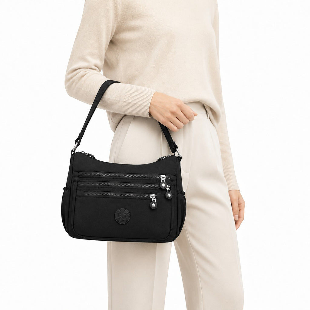 Sac bandoulière noir en nylon Univers Sac avec plusieurs fermetures éclair et une poche extérieure zippée.