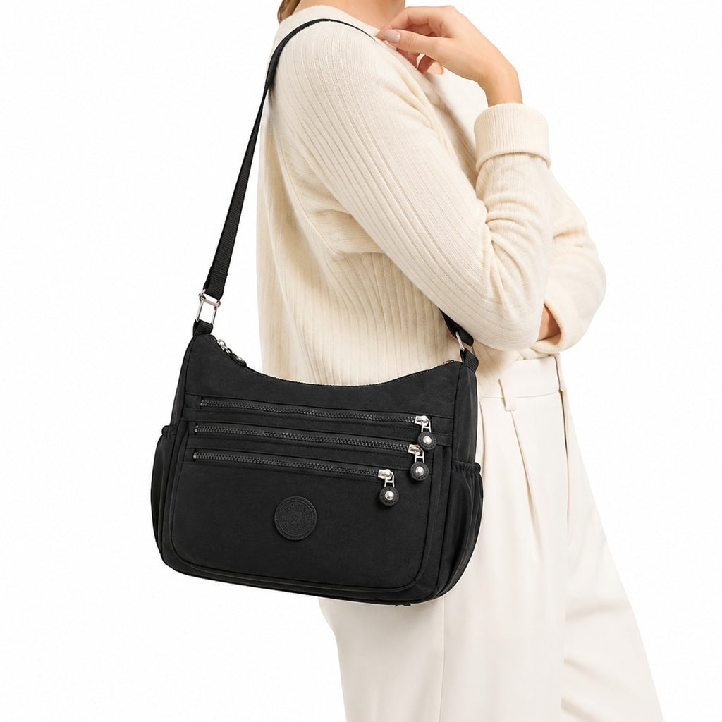 Sac bandoulière noir en nylon pour femme, Univers Sac, avec plusieurs poches zippées et une bandoulière réglable, idéal pour les voyages décontractés.