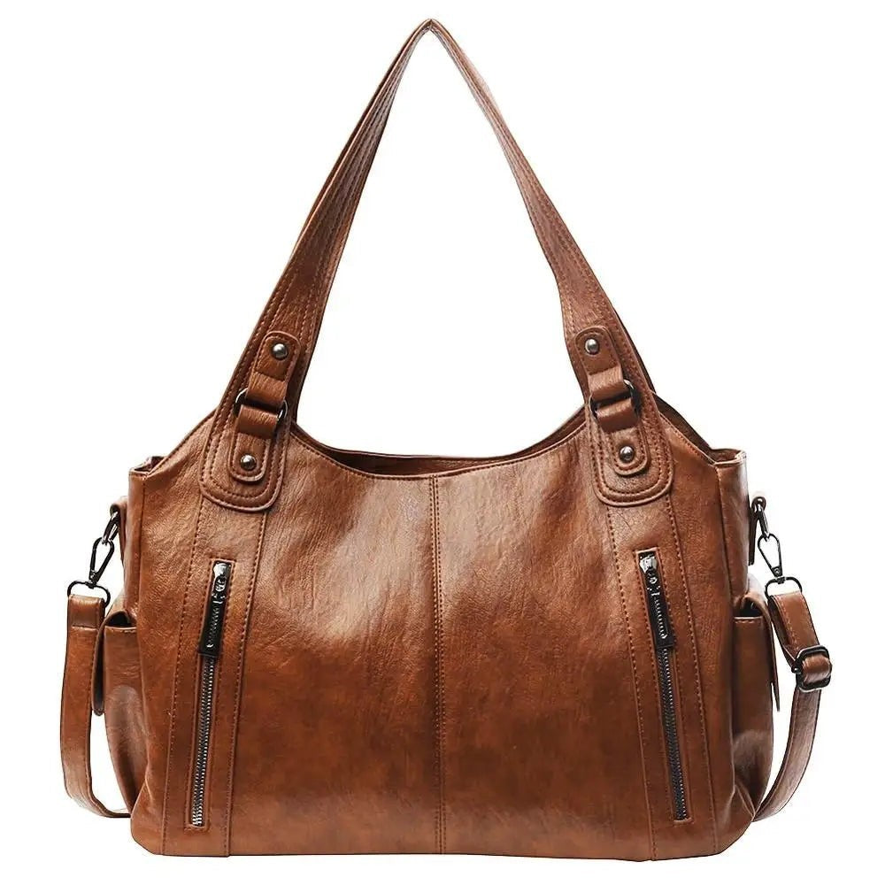 Sac bandoulière marron en cuir synthétique pour femme, style vintage, avec fermeture éclair et poche extérieure.