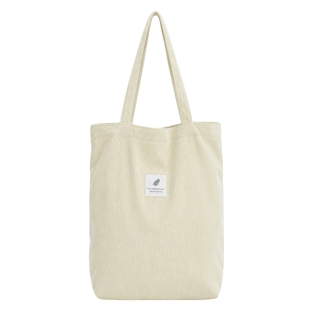 Sac fourre-tout Univers Sac en velours côtelé crème avec deux anses et une poche intérieure zippée.
