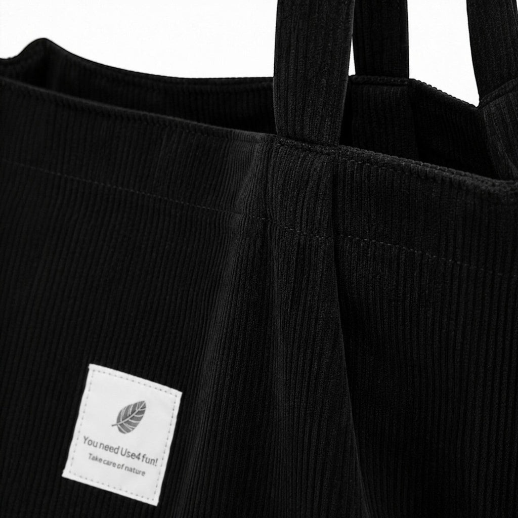 Sac fourre-tout noir en velours côtelé souple avec deux anses et une poche intérieure pour téléphone portable. Univers Sac.