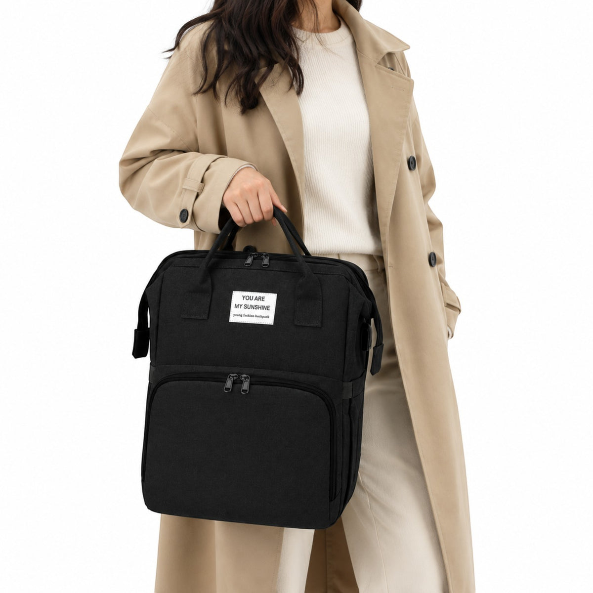 Sac à langer Univers Sac noir multifonction avec poignées et fermeture éclair, porté à la main par une femme