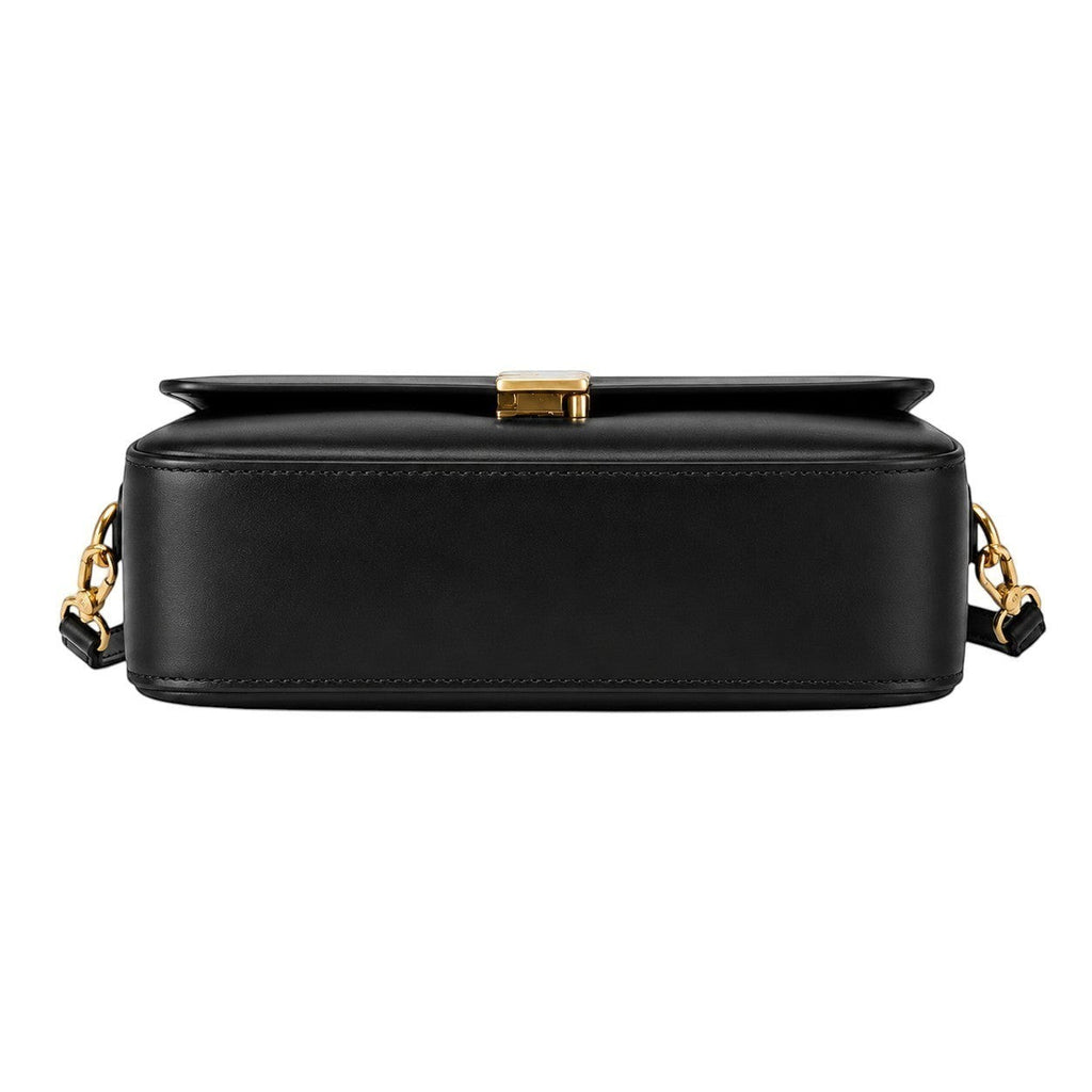 Sac à main noir en cuir véritable pour femme, avec fermoir doré et bandoulière chaîne, style vintage.