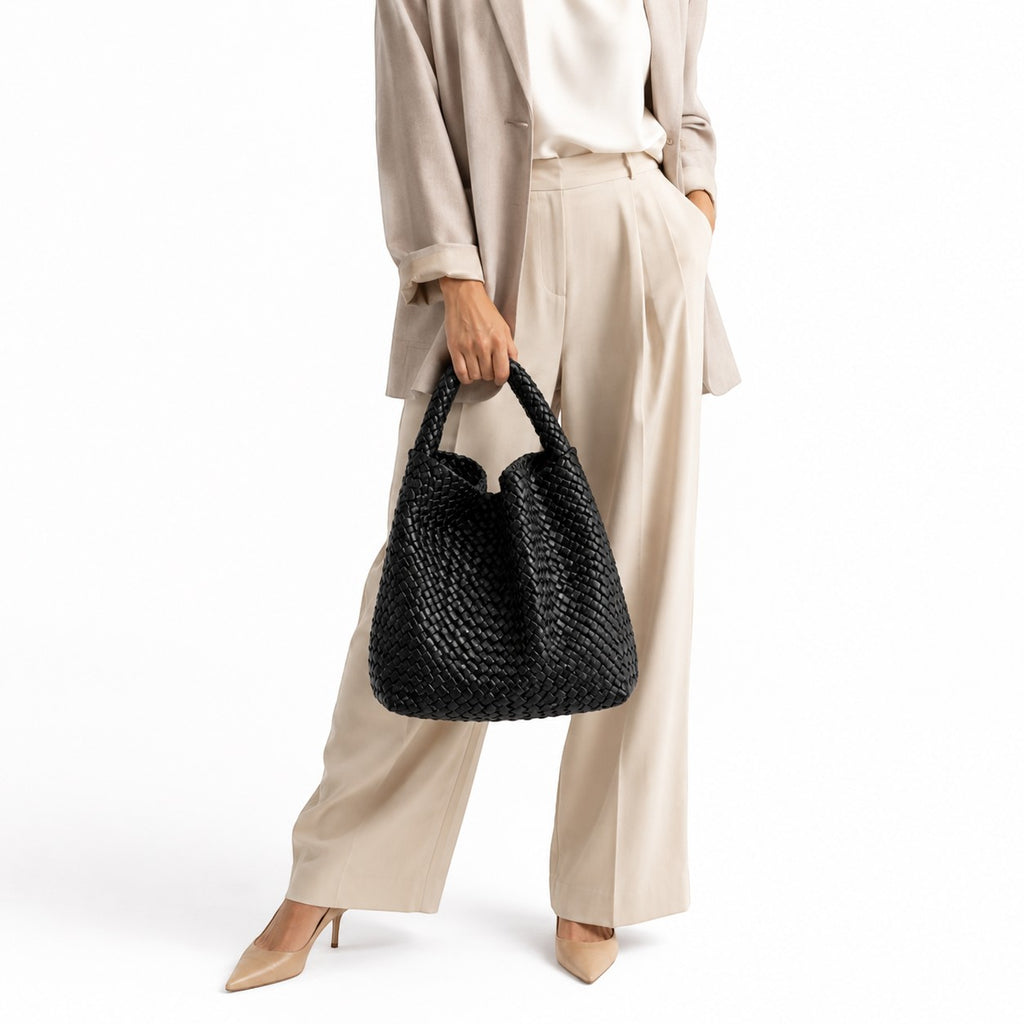Sac à main noir tressé en PU souple, porté par une femme en tenue de bureau décontractée. Univers Sac.