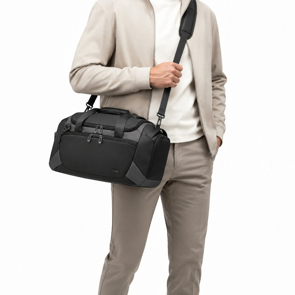 Sac de sport Univers Sac noir en tissu Oxford imperméable, porté à l'épaule par un homme en tenue décontractée.