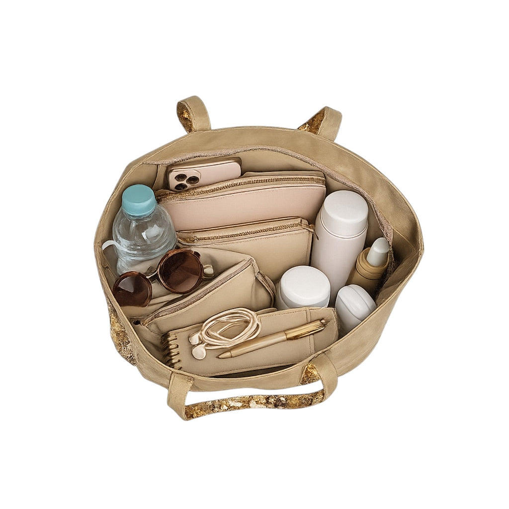 Sac fourre-tout en toile beige Univers Sac orné de paillettes dorées, avec deux anses. Il contient des accessoires de voyage.