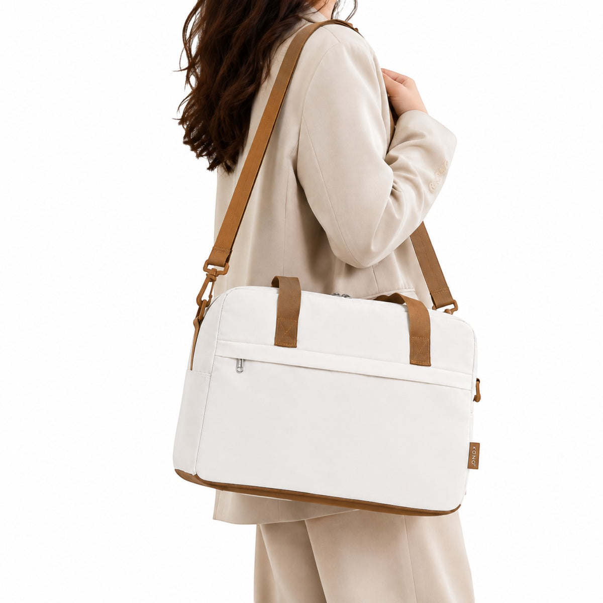 Sac de voyage Univers Sac blanc et marron, format cabine 40x20x25 cm, porté à l'épaule par une femme en tailleur.