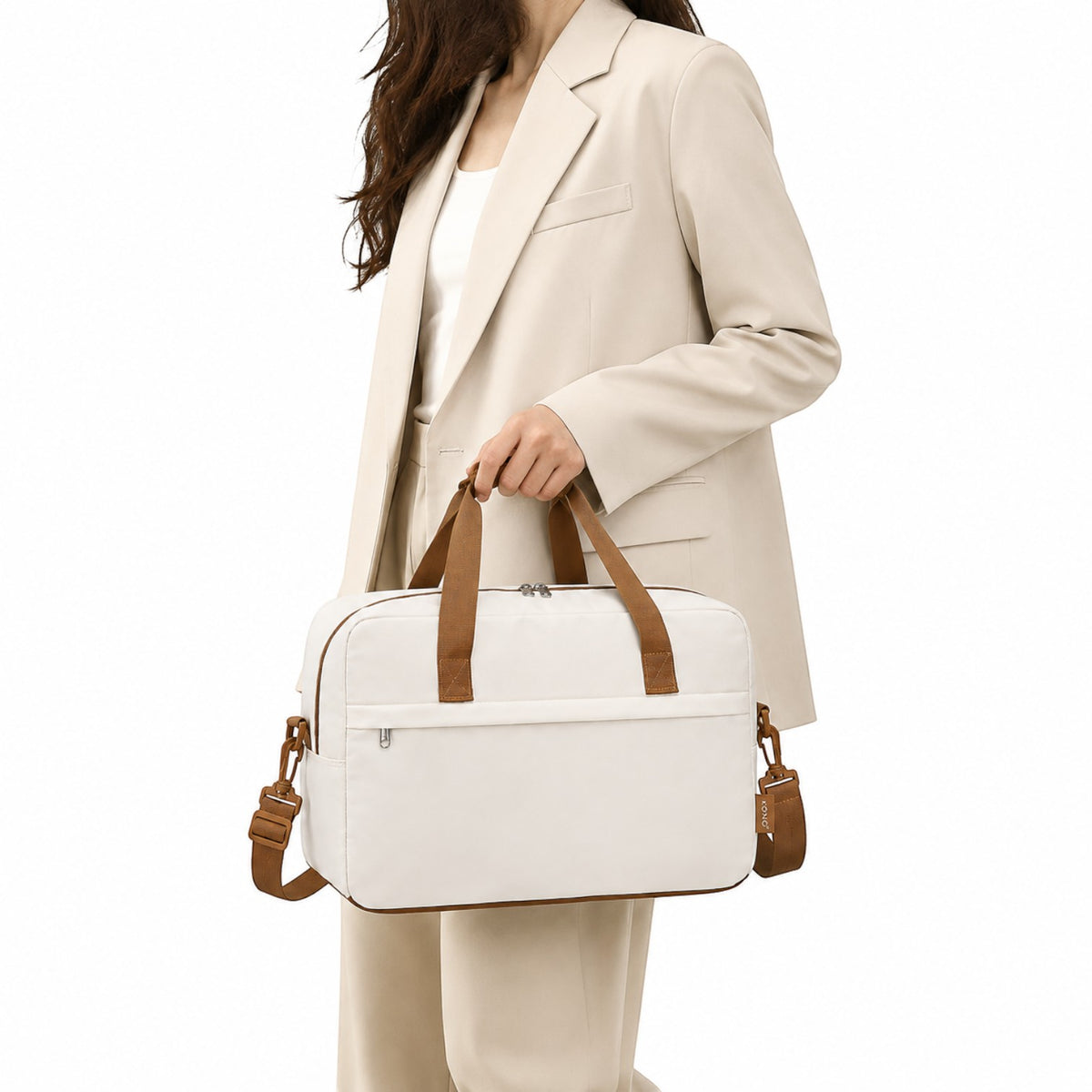 Sac de voyage Univers Sac blanc et marron, léger, format cabine 40x20x25 cm, porté à la main par une femme en tailleur.