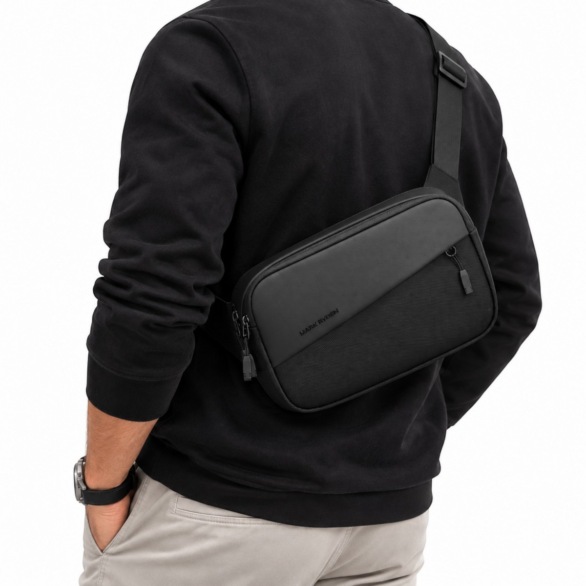 Sacoche bandoulière noire MARK RYDEN en tissu Oxford imperméable portée à l'épaule par un homme, style urbain moderne.